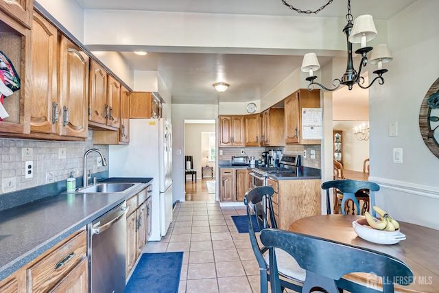 kitchen with sink, hanging light fixtures, a notable chandelier, light tile patterned flooring, and appliances with stainless steel finishes