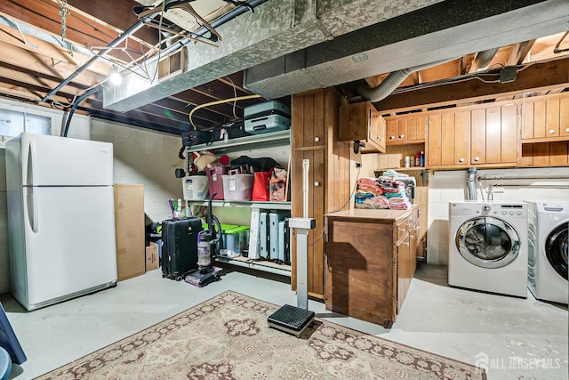 basement featuring white refrigerator and washing machine and dryer