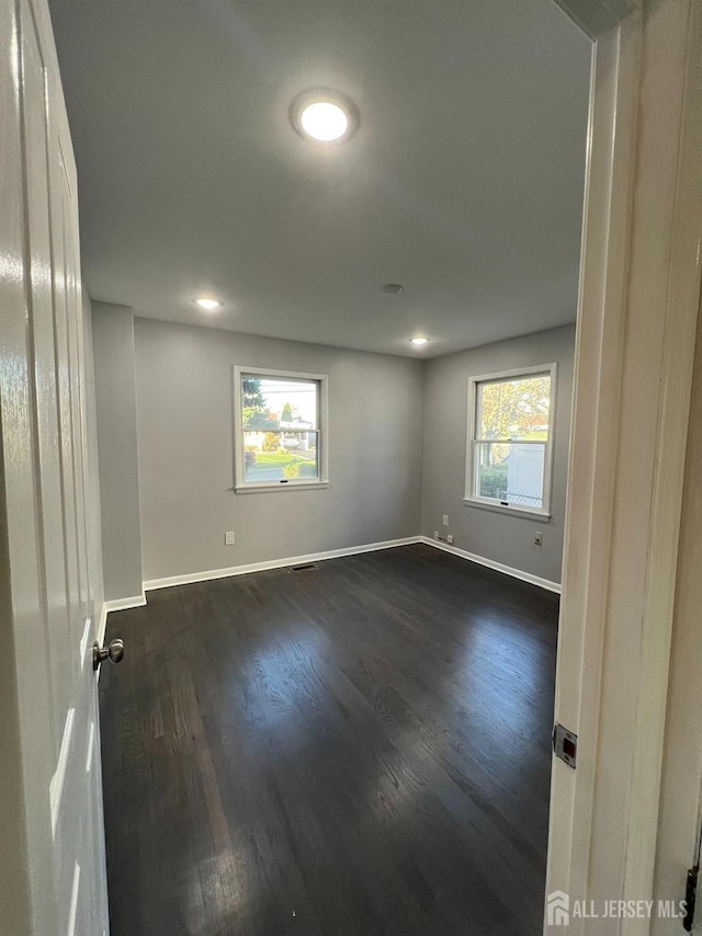 unfurnished room with dark wood-style floors, baseboards, and recessed lighting