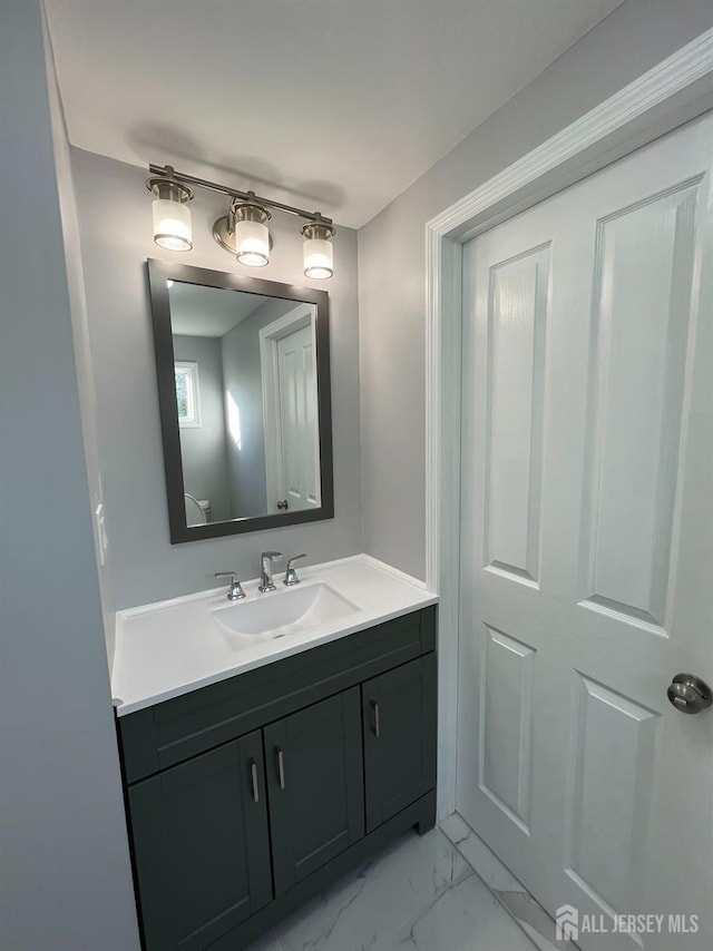 bathroom featuring vanity and marble look tiles