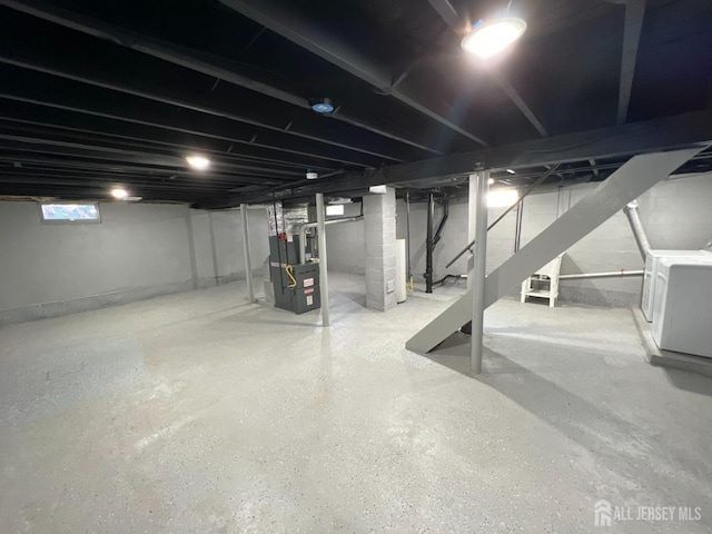 basement with heating unit, stairs, and washer / clothes dryer