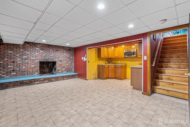 34 Brookside Ave, Old Bridge, NJ 08857 - unfurnished living room featuring a paneled ceiling, stairs, a brick fireplace, recessed lighting, and wooden walls
