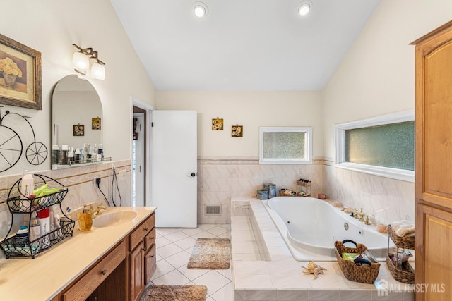 34 Brookside Ave, Old Bridge, NJ 08857 - bathroom with vaulted ceiling, a whirlpool tub, vanity, tile patterned flooring, and a wainscoted wall