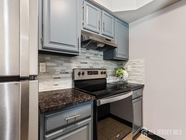 kitchen featuring stainless steel electric stove, light tile patterned floors, dark stone counters, and decorative backsplash