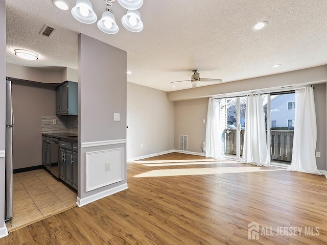 kitchen featuring gray cabinetry, a textured ceiling, dishwasher, light hardwood / wood-style floors, and ceiling fan with notable chandelier