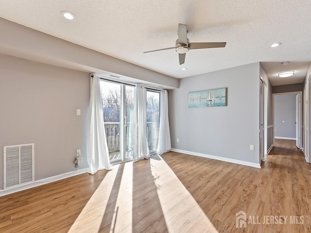 empty room with wood-type flooring and a textured ceiling