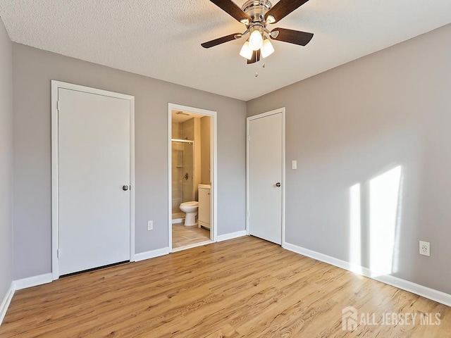 unfurnished bedroom with ceiling fan, ensuite bathroom, light hardwood / wood-style flooring, and a textured ceiling