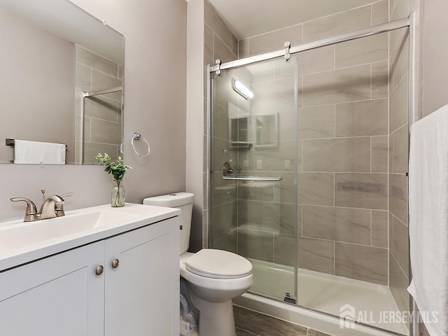 bathroom with vanity, an enclosed shower, and toilet