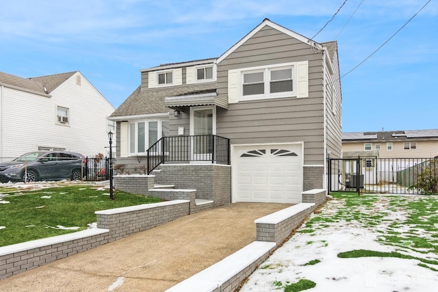 view of front of property with driveway, an attached garage, fence, and a shingled roof