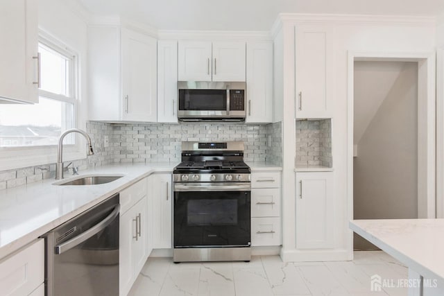 kitchen featuring sink, tasteful backsplash, crown molding, stainless steel appliances, and white cabinets