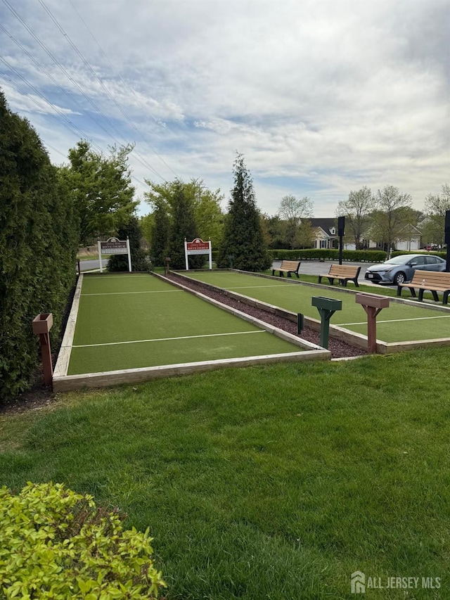 view of home's community featuring a bocce ball area and a yard