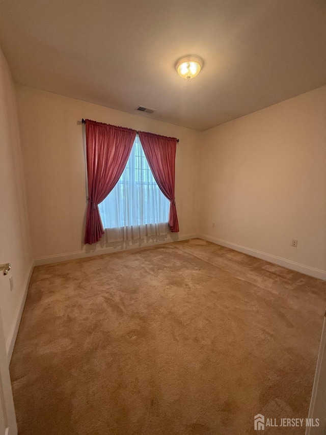 carpeted spare room with baseboards