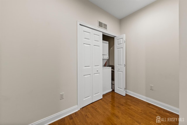 empty room with baseboards and wood finished floors