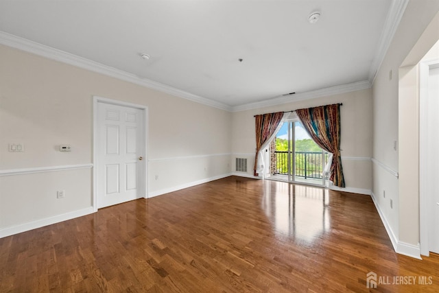 empty room featuring ornamental molding, wood finished floors, a smoke detector, and baseboards