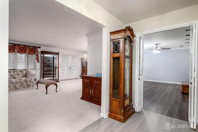 corridor with a notable chandelier, crown molding, and hardwood / wood-style floors