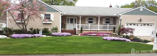 ranch-style home featuring a garage, a front lawn, and covered porch