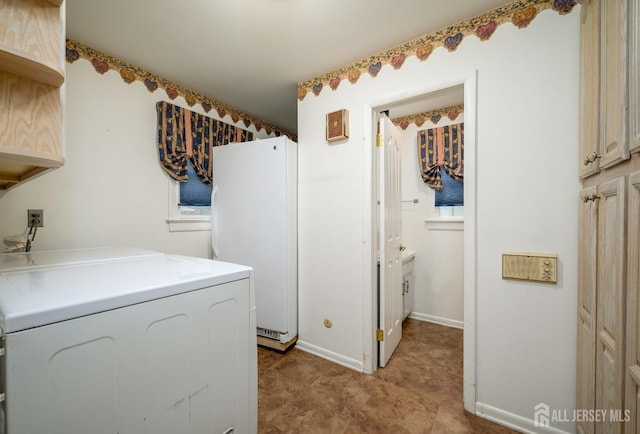 clothes washing area with cabinets