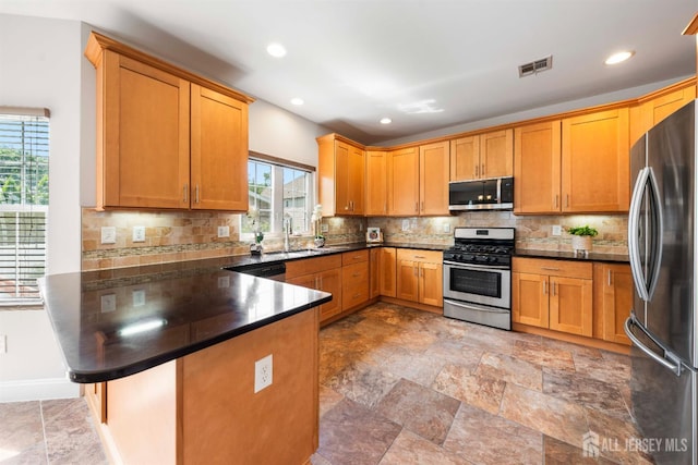 841 Harrell Ave, Woodbridge Proper, NJ 07095 - kitchen with a peninsula, appliances with stainless steel finishes, dark countertops, tasteful backsplash, and light stone finish flooring