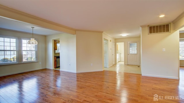 empty room featuring ornamental molding and light wood-type flooring