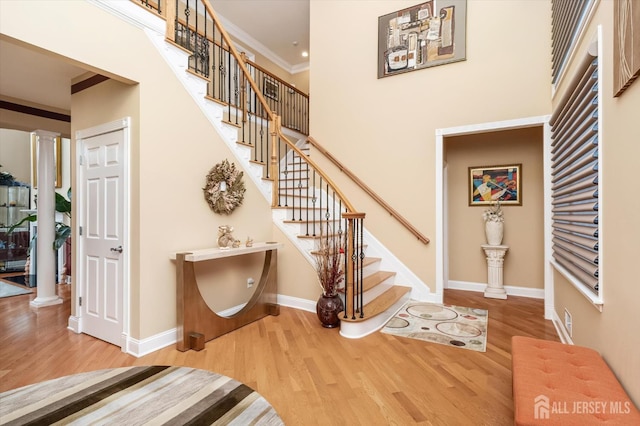 9 Bouvier Ln, South Brunswick, NJ 08816 - stairs featuring ornate columns, wood finished floors, baseboards, a high ceiling, and ornamental molding