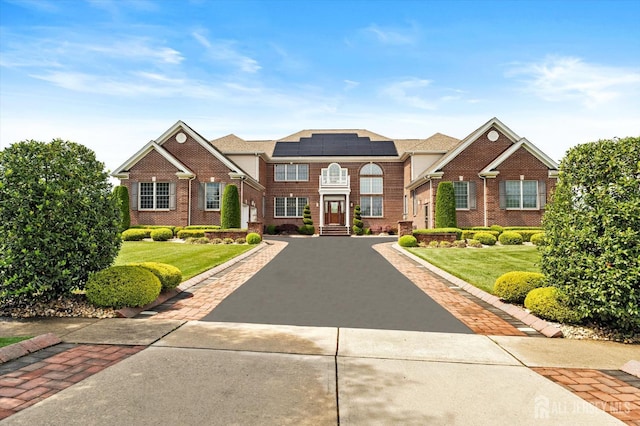 9 Bouvier Ln, South Brunswick, NJ 08816 - view of front of house featuring asphalt driveway, solar panels, brick siding, and a front lawn