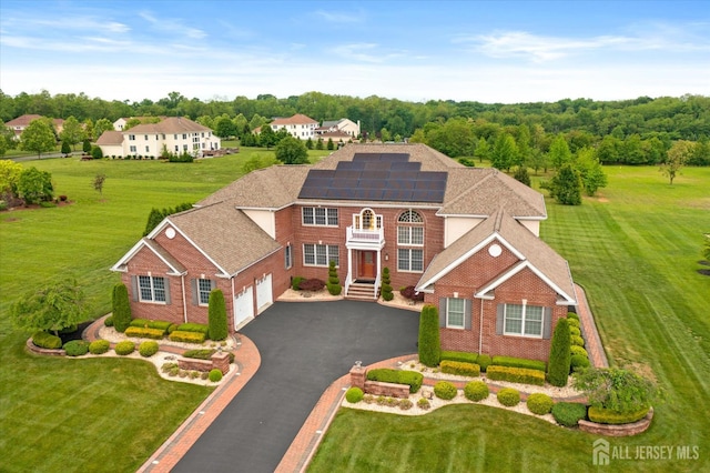9 Bouvier Ln, South Brunswick, NJ 08816 - view of front of home with roof mounted solar panels, an attached garage, a front lawn, asphalt driveway, and brick siding