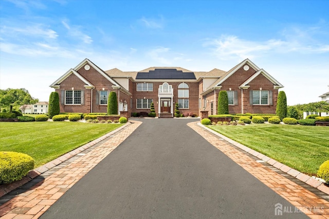 9 Bouvier Ln, South Brunswick, NJ 08816 - view of front of home with solar panels, a front lawn, and brick siding