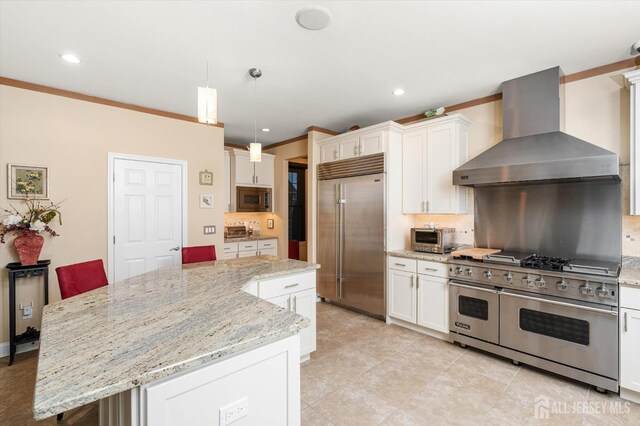 9 Bouvier Ln, South Brunswick, NJ 08816 - kitchen featuring built in appliances, wall chimney exhaust hood, tasteful backsplash, white cabinetry, and recessed lighting