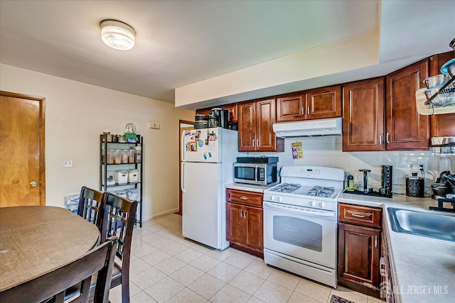 84 Kossuth St, Piscataway, NJ 08854 - kitchen with white appliances, under cabinet range hood, light countertops, light tile patterned flooring, and backsplash