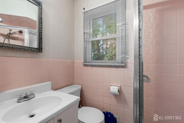 910 Curtis Pl, North Brunswick, NJ 08902 - full bathroom featuring a tile shower, tile walls, vanity, and wainscoting