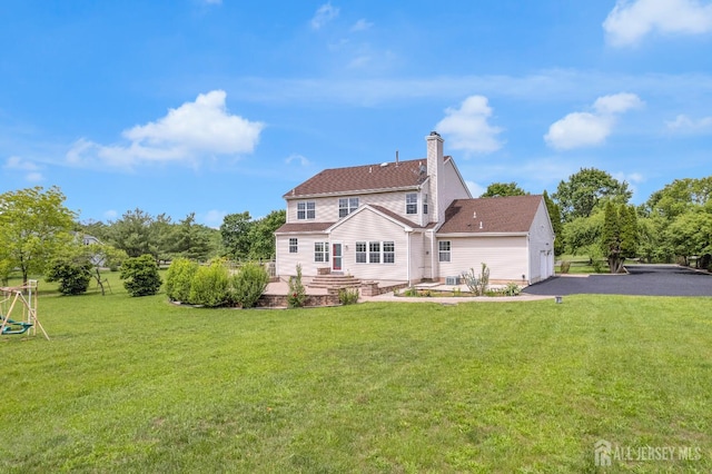 6 Garretson Dr, Franklin, NJ 08823 - back of house with a lawn, a garage, asphalt driveway, and a chimney