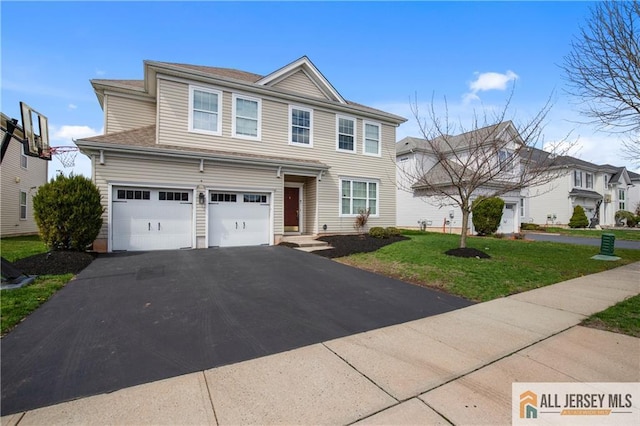 view of front of property with a garage, a front yard, and aphalt driveway