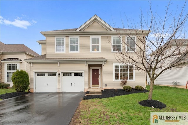 traditional-style house featuring an attached garage, a front lawn, and aphalt driveway
