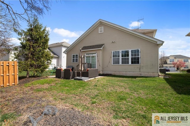 back of property with a lawn, outdoor lounge area, and fence