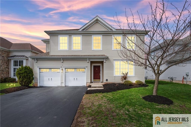 traditional-style house with an attached garage, aphalt driveway, and a front yard