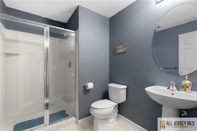 bathroom featuring baseboards, tile patterned floors, toilet, and a shower stall