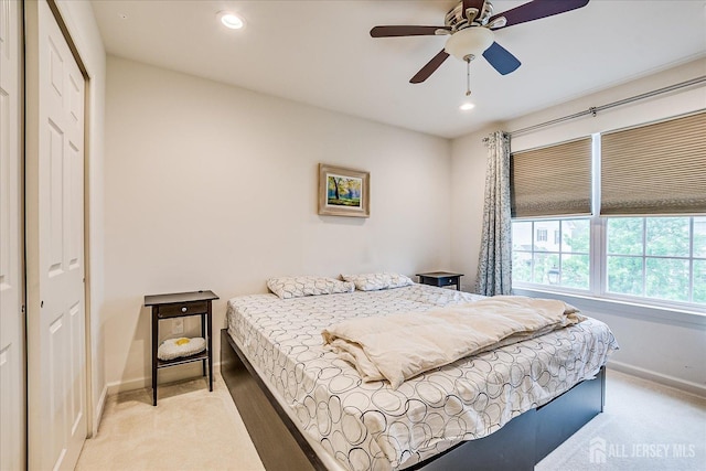 bedroom featuring light colored carpet, baseboards, a closet, recessed lighting, and a ceiling fan