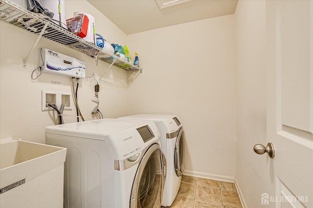 laundry area with washing machine and dryer, baseboards, and light tile patterned floors