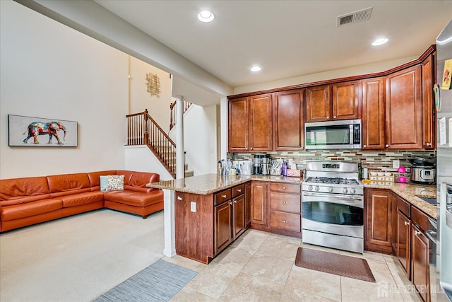 kitchen with stainless steel appliances, a peninsula, light stone countertops, tasteful backsplash, and recessed lighting
