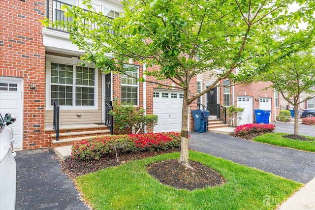 view of front of property featuring brick siding and asphalt driveway