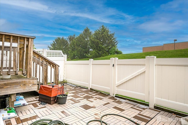 view of patio featuring fence, a gate, and a wooden deck