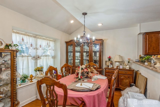 dining area featuring light wood-type flooring, vaulted ceiling, a notable chandelier, and recessed lighting