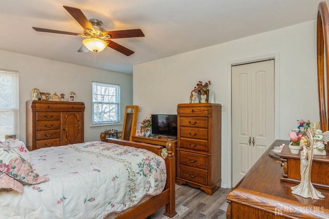 bedroom featuring light wood-type flooring, a closet, and a ceiling fan