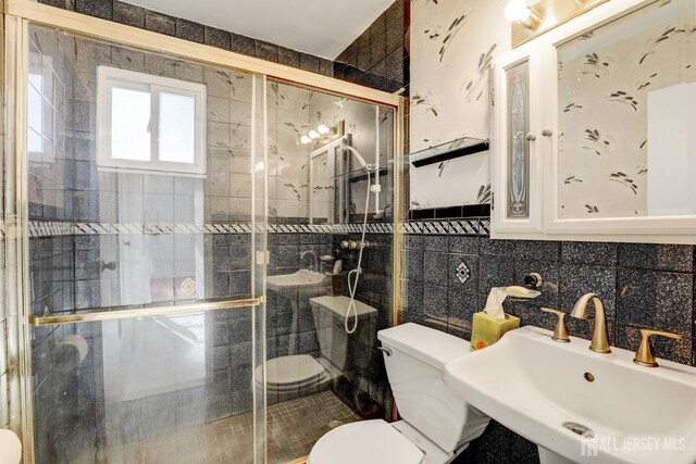 bathroom featuring sink, tile walls, backsplash, walk in shower, and toilet