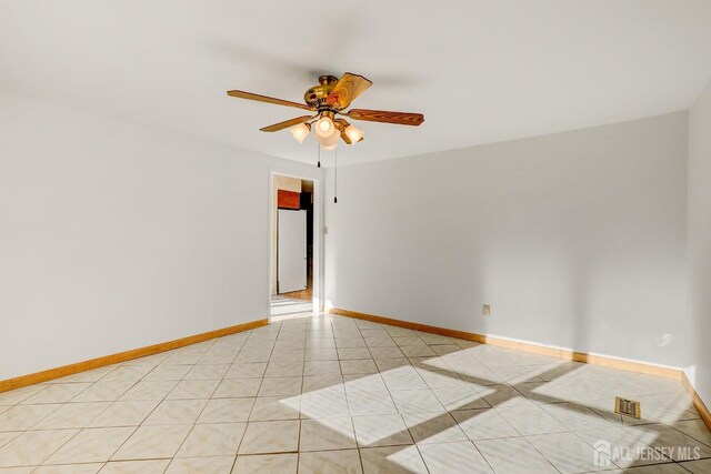 unfurnished room with light tile patterned floors and ceiling fan