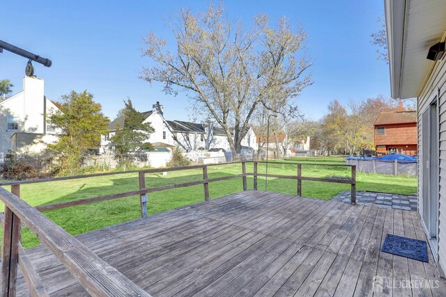 wooden deck with a pool and a yard