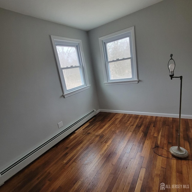spare room with wood-type flooring, a baseboard radiator, and baseboards