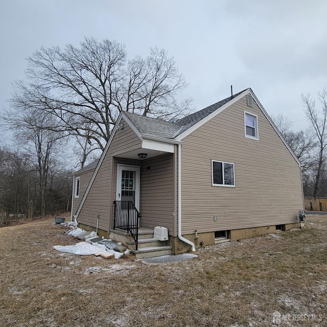 view of home's exterior with roof with shingles