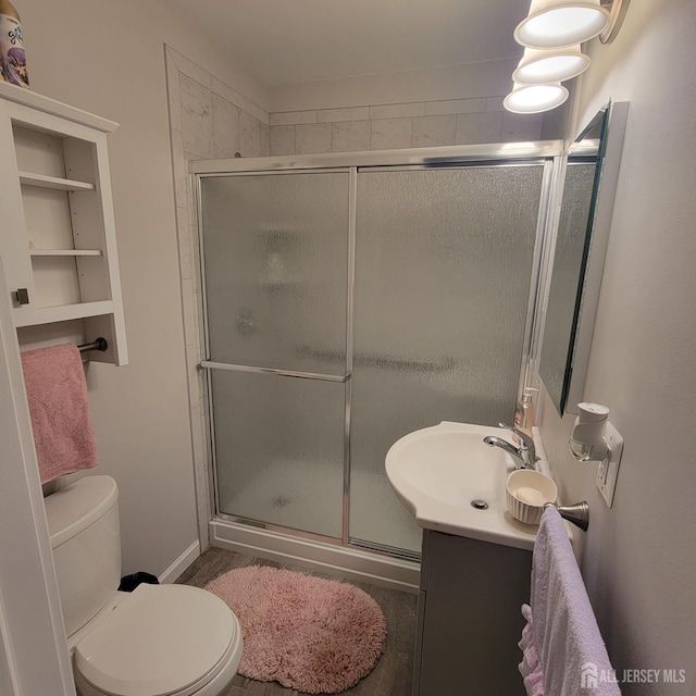 bathroom with vanity, a stall shower, and toilet