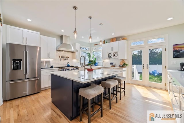 11 Hilltop Blvd N, East Brunswick, NJ 08816 - kitchen featuring high quality fridge, wall chimney range hood, white cabinets, light countertops, and backsplash